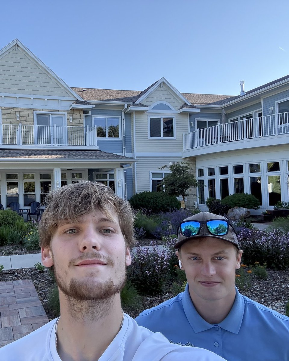 The two-man Kraken Window Cleaning team in front of a Sioux Falls building with rows of freshly cleaned windows